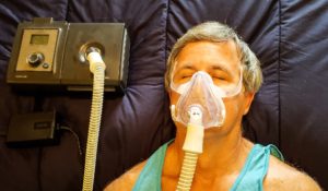 Man using breathing apparatus for sleep apnea.