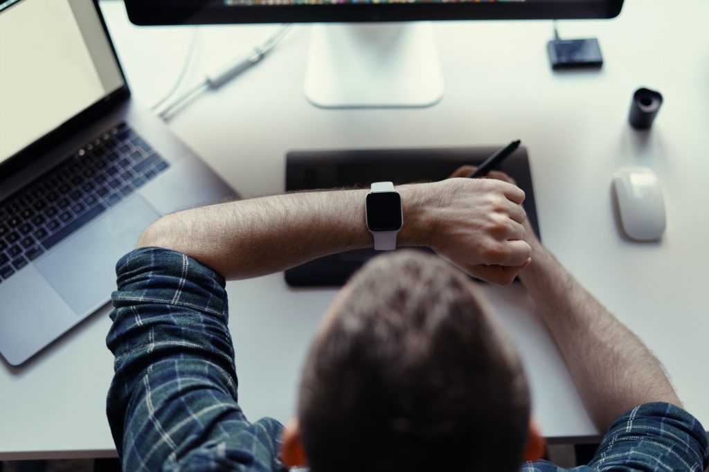 Man watching smart watch while working